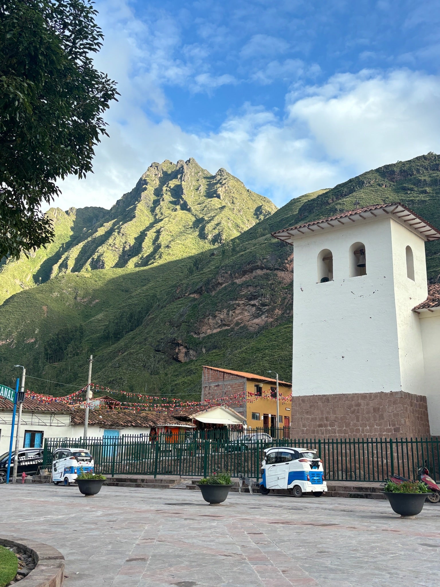 Small town square with a white tower and mountain in the background